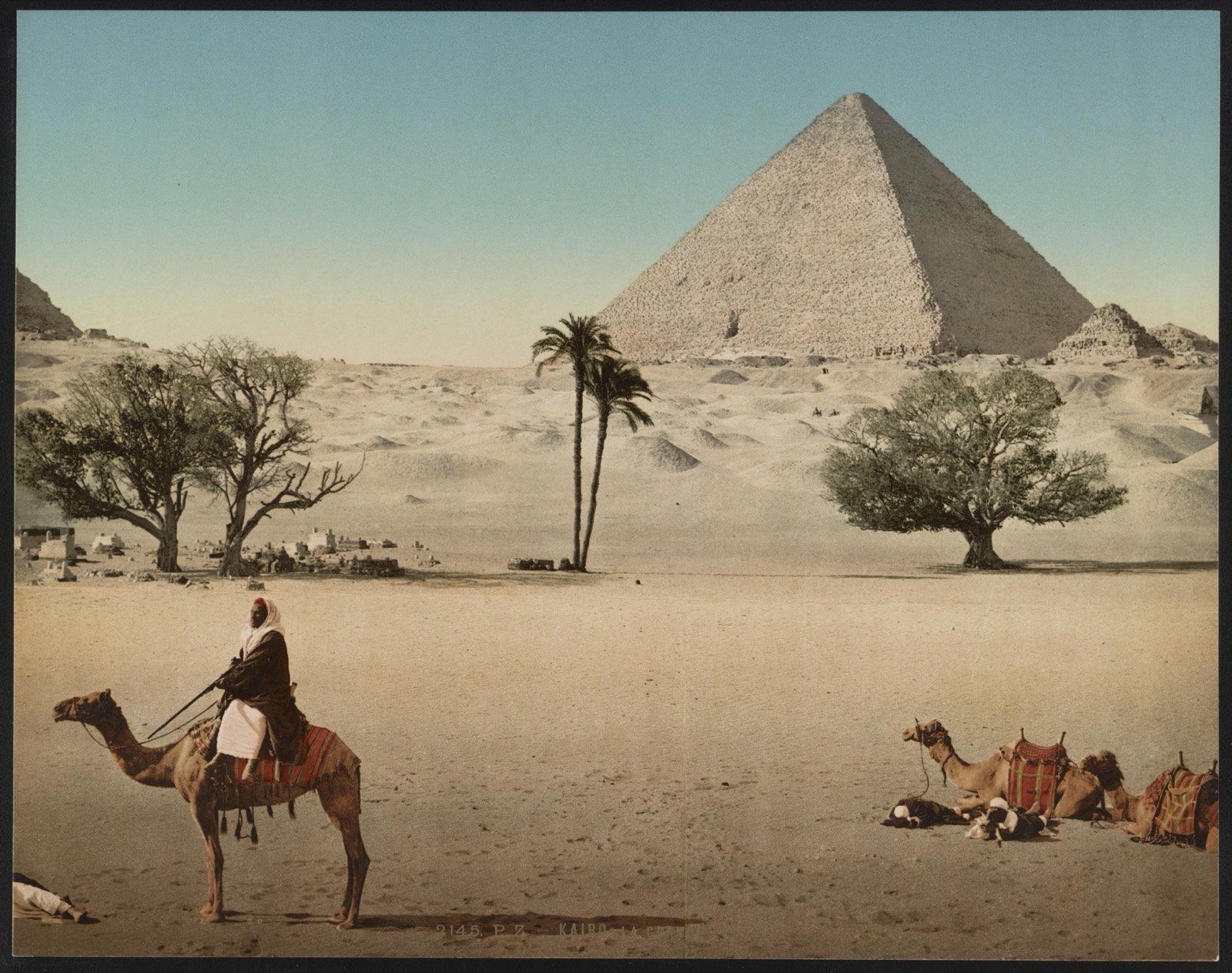 The Great Pyramid of Giza, with travelers and camels in the desert, Egypt, c. 1890–1900.